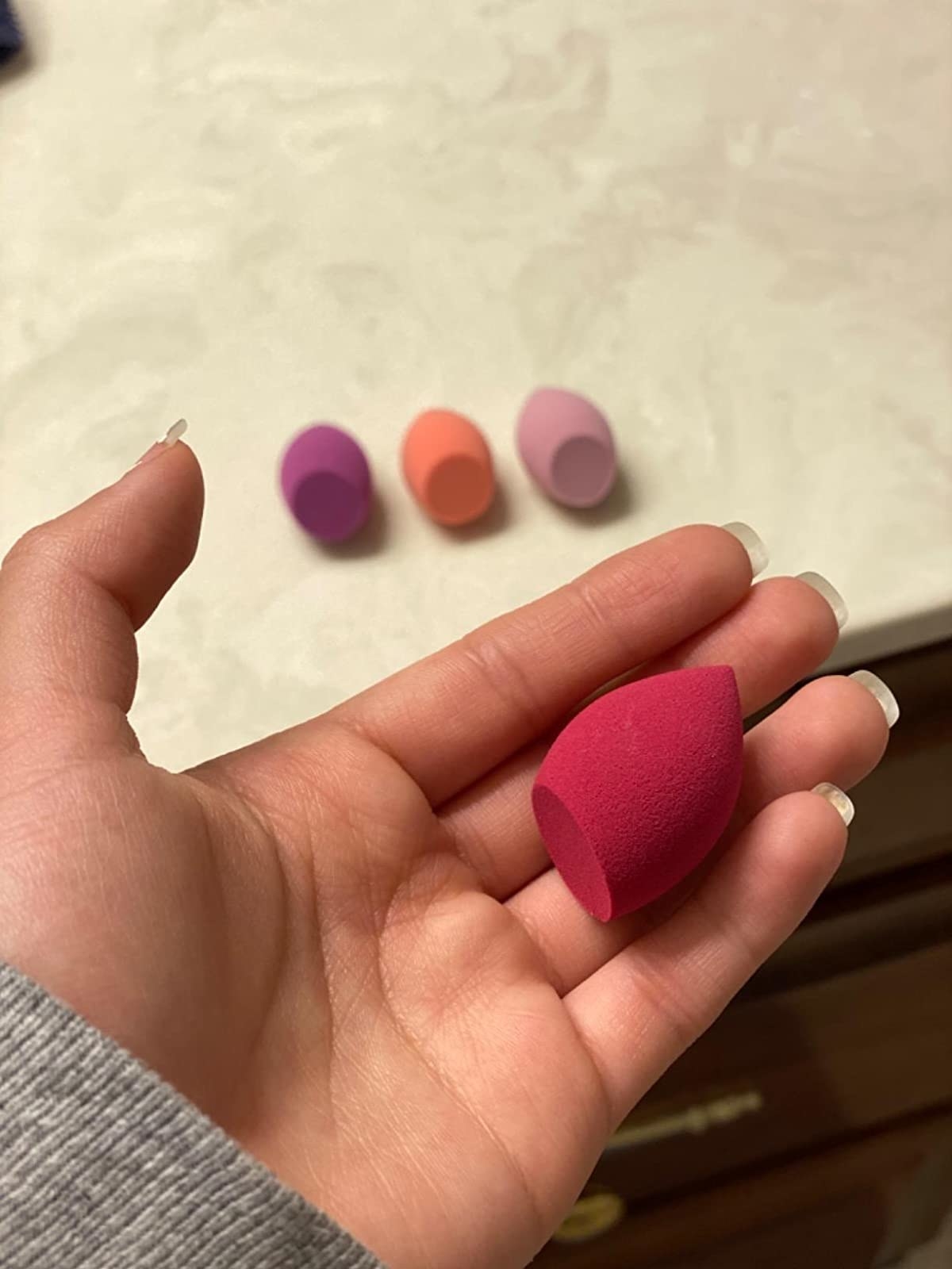 Reviewer holding one of the makeup sponges