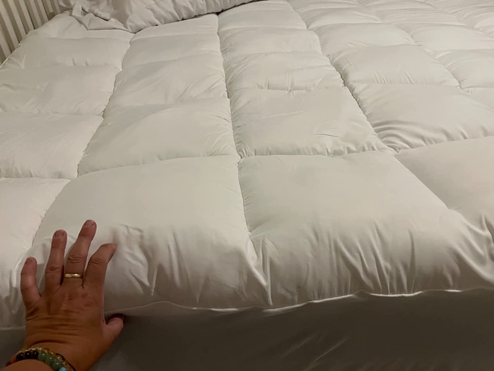 Reviewer showing the thickness of the mattress topper