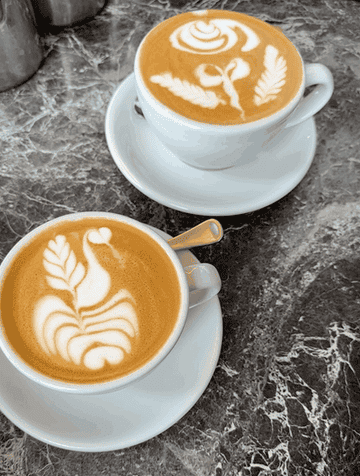 A gif of two lattes with latte art on top