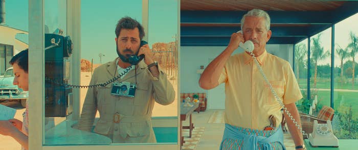Jason Schwartzman on a payphone on the left and Tom Hank on a landline phone on the right