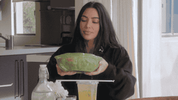 Kim Kardashian shaking a salad in a container