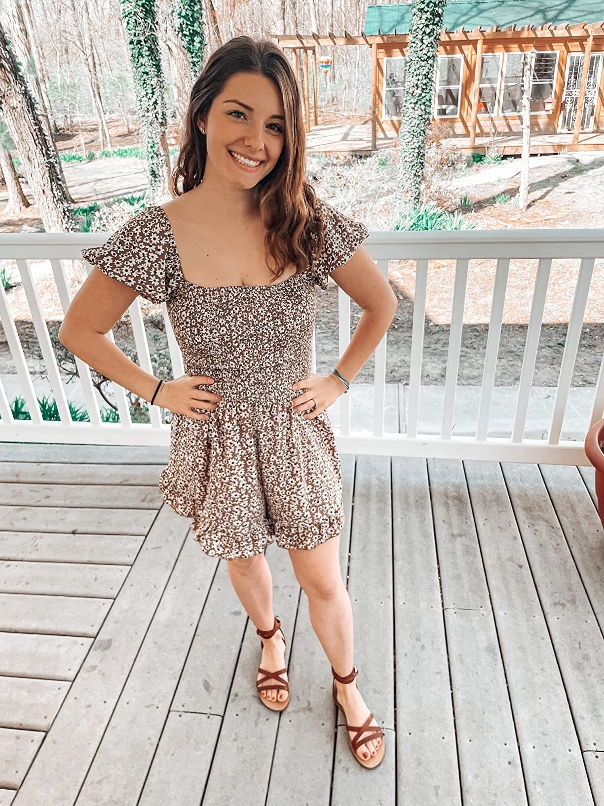 a reviewer wearing the floral romper in white and brown