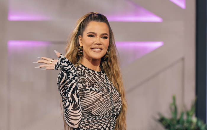 Khloé smiling and waving