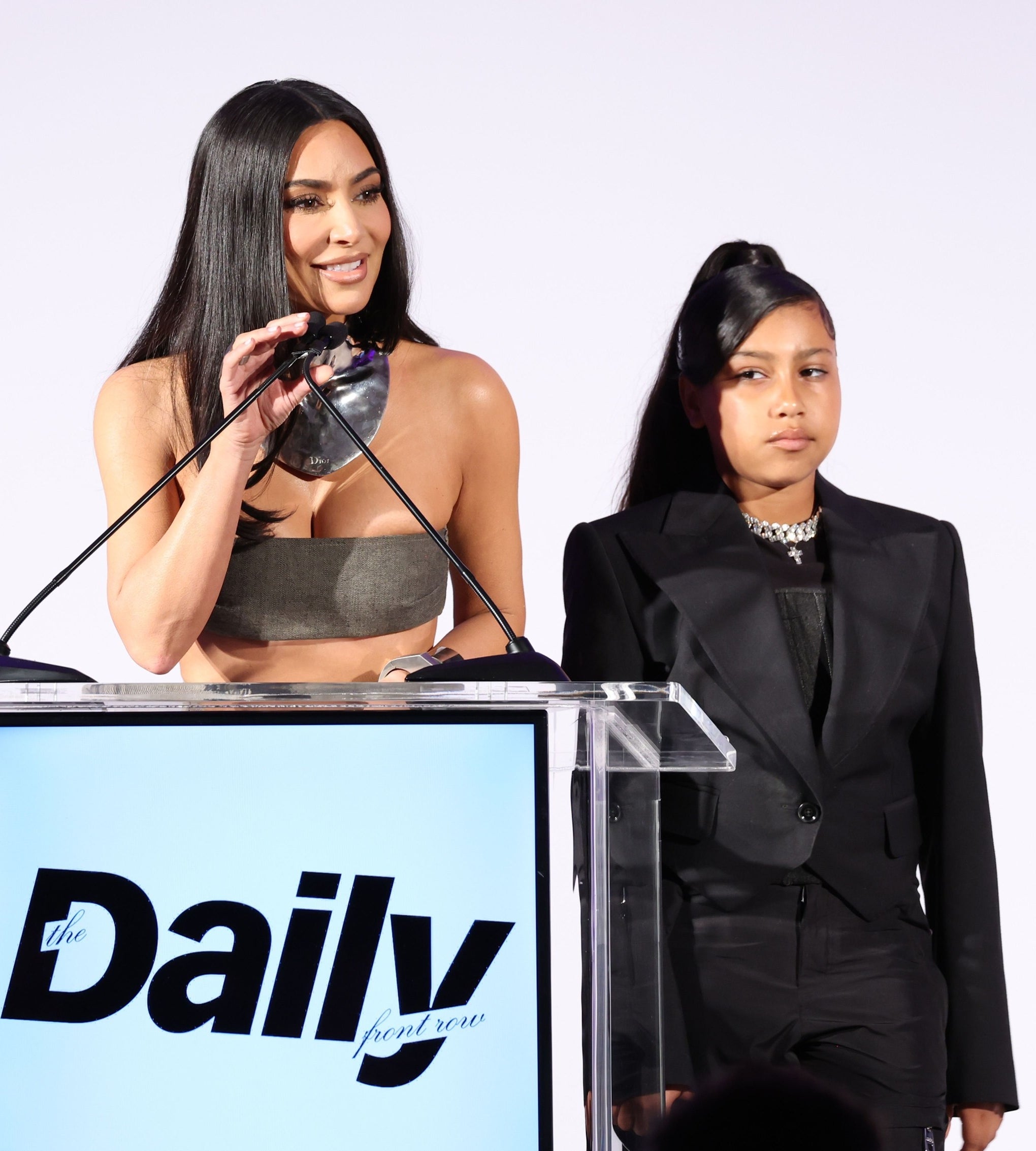 north standing next to kim as she speaks at a podium