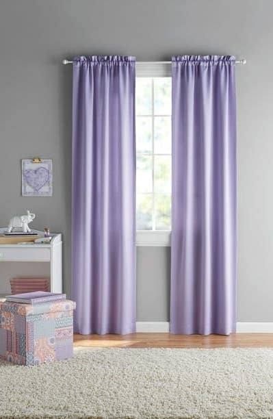 Purple darkening curtains on the window of a child&#x27;s bedroom.