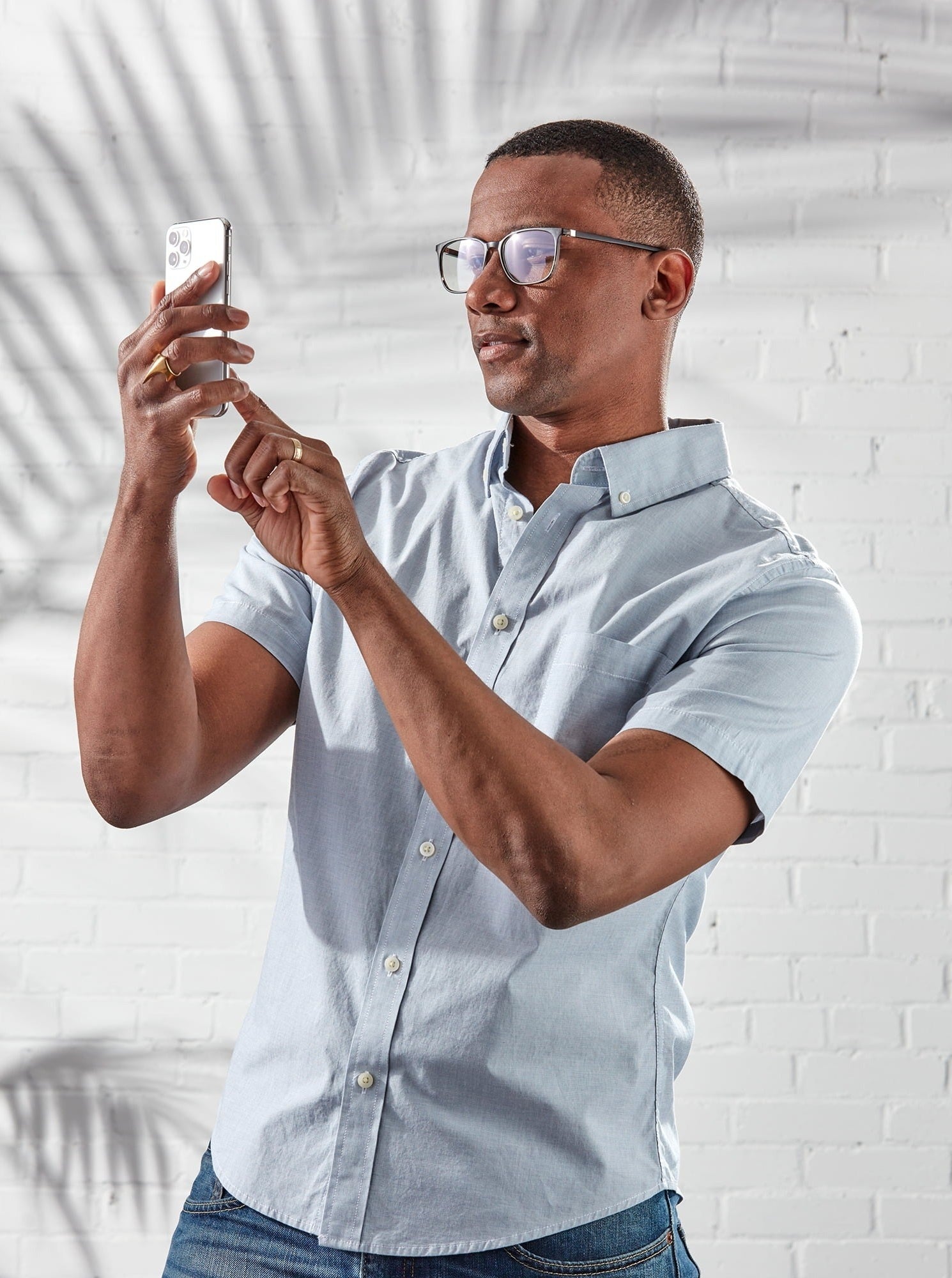 model wearing the glasses and looking at a phone