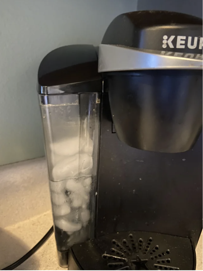 Close-up of a coffee-maker water reservoir filled with ice cubes