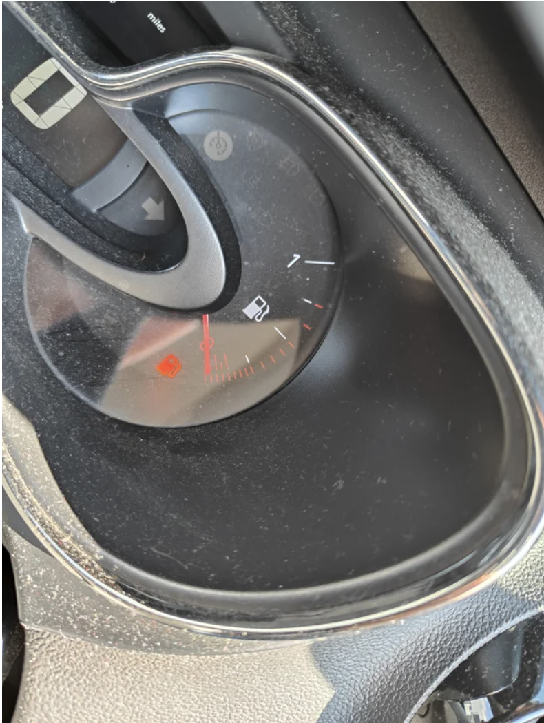 A car&#x27;s fuel gauge at E
