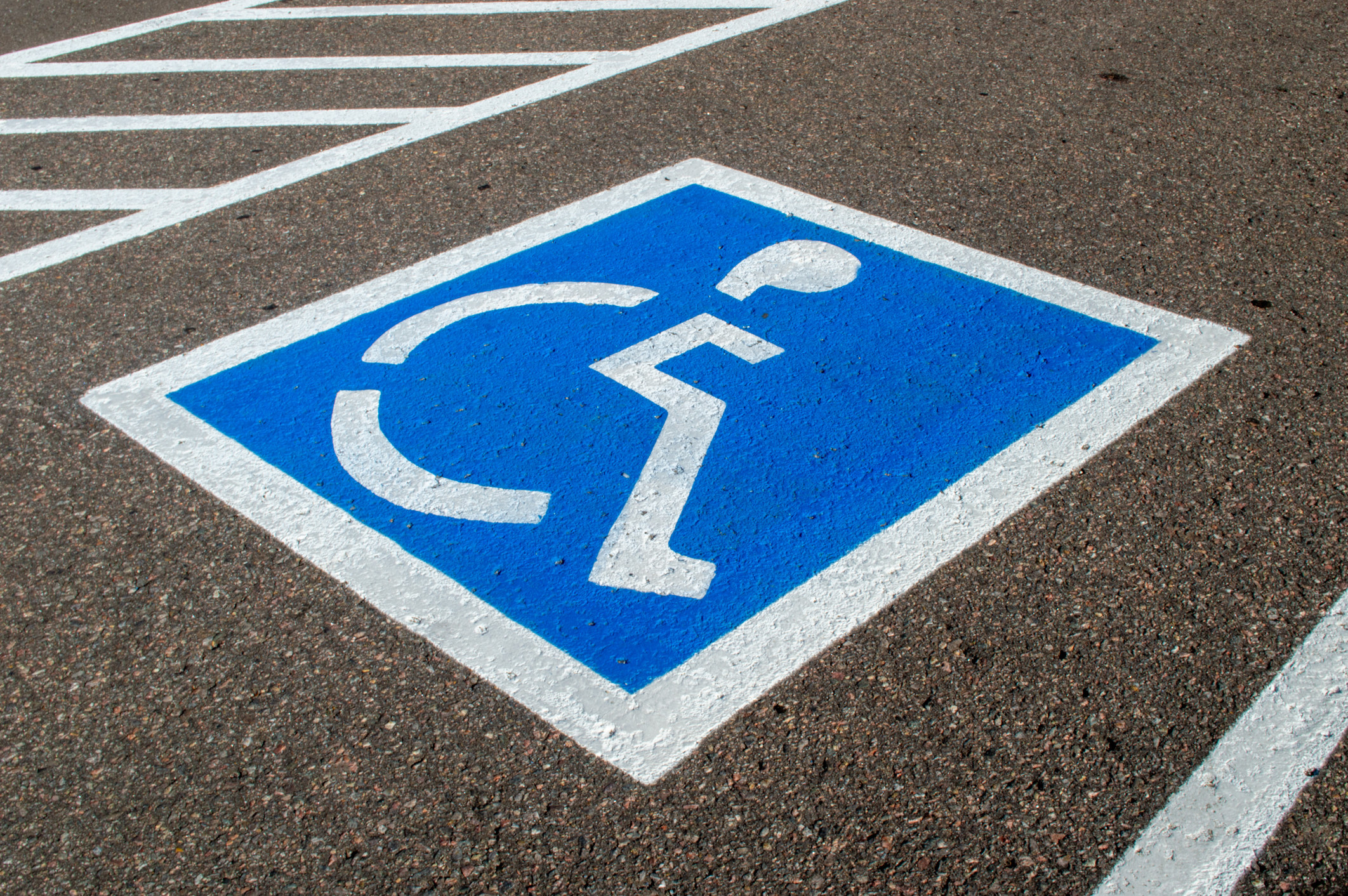 空的停车位与残疾人停车标志在一个停车场沥青
