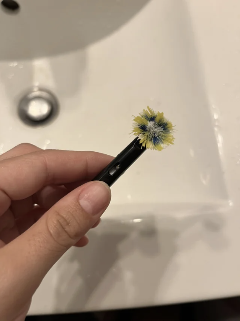 A tiny toothbrush with completely flattened bristles