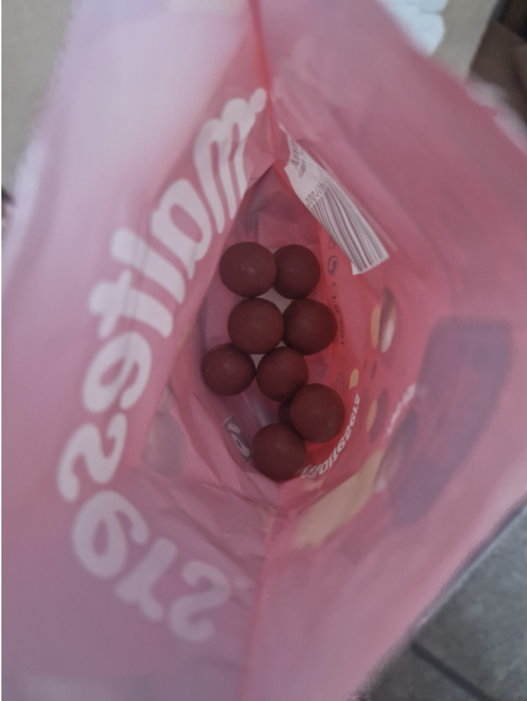 A large bag of Maltesers malted milk balls with only a handful at the bottom