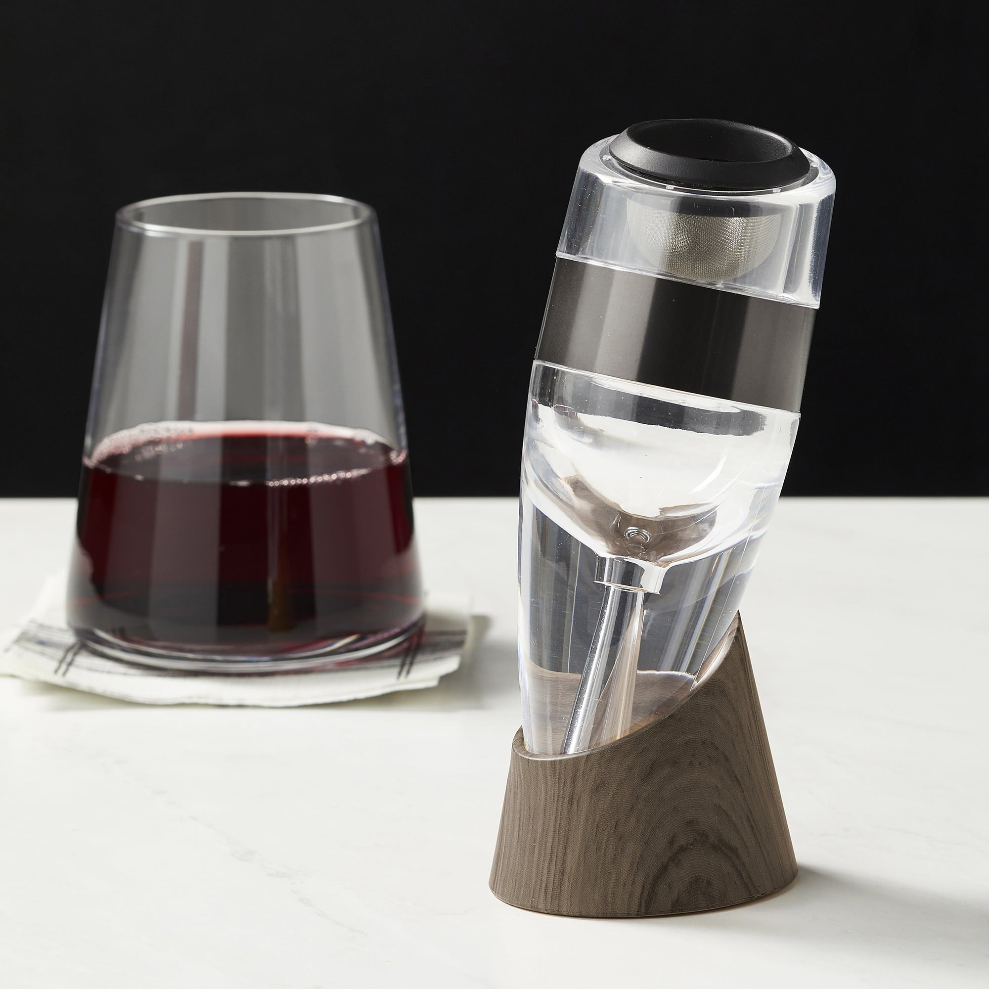 Wine aerator with glass of red wine in the back