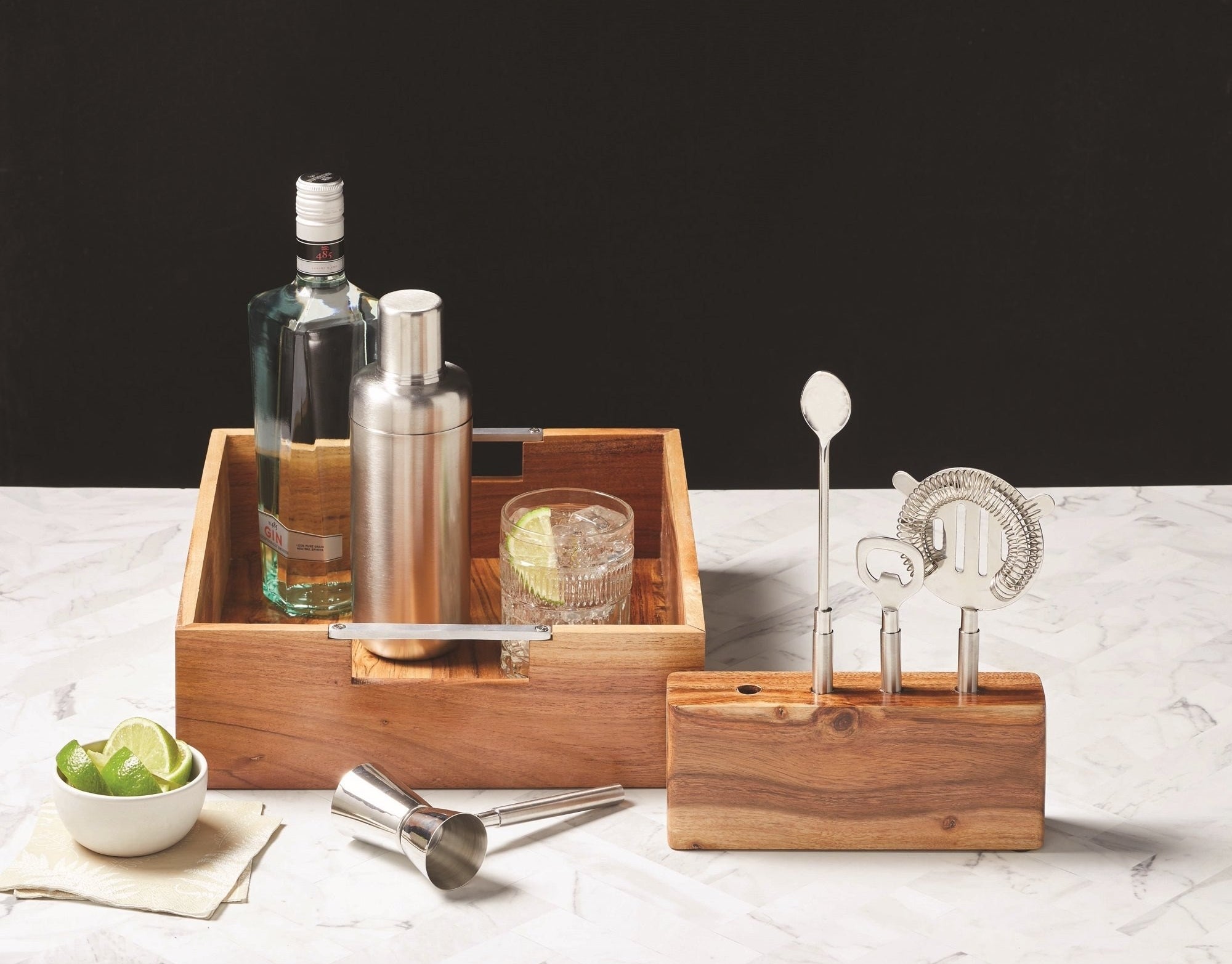Stainless steel mixology kit in wooden case with cocktail and bottle of liquor