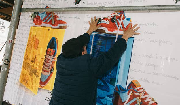 A worker applies a wheatpaste poster of the Unheardof x Adidas Rivalry Low to a scaffold in New York City in May