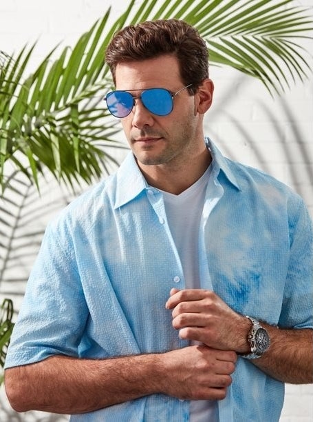 Model wearing black framed aviator sunglasses with blue lens