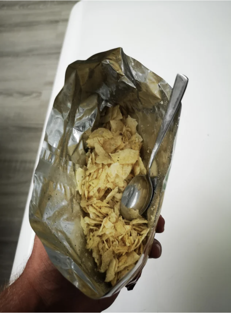 A spoon in a bag of small chips