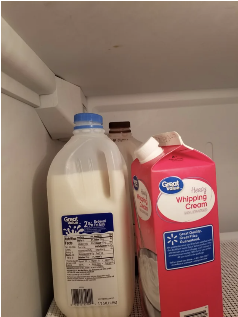 Cartons and jugs of milk in the fridge with the tops on very loosely