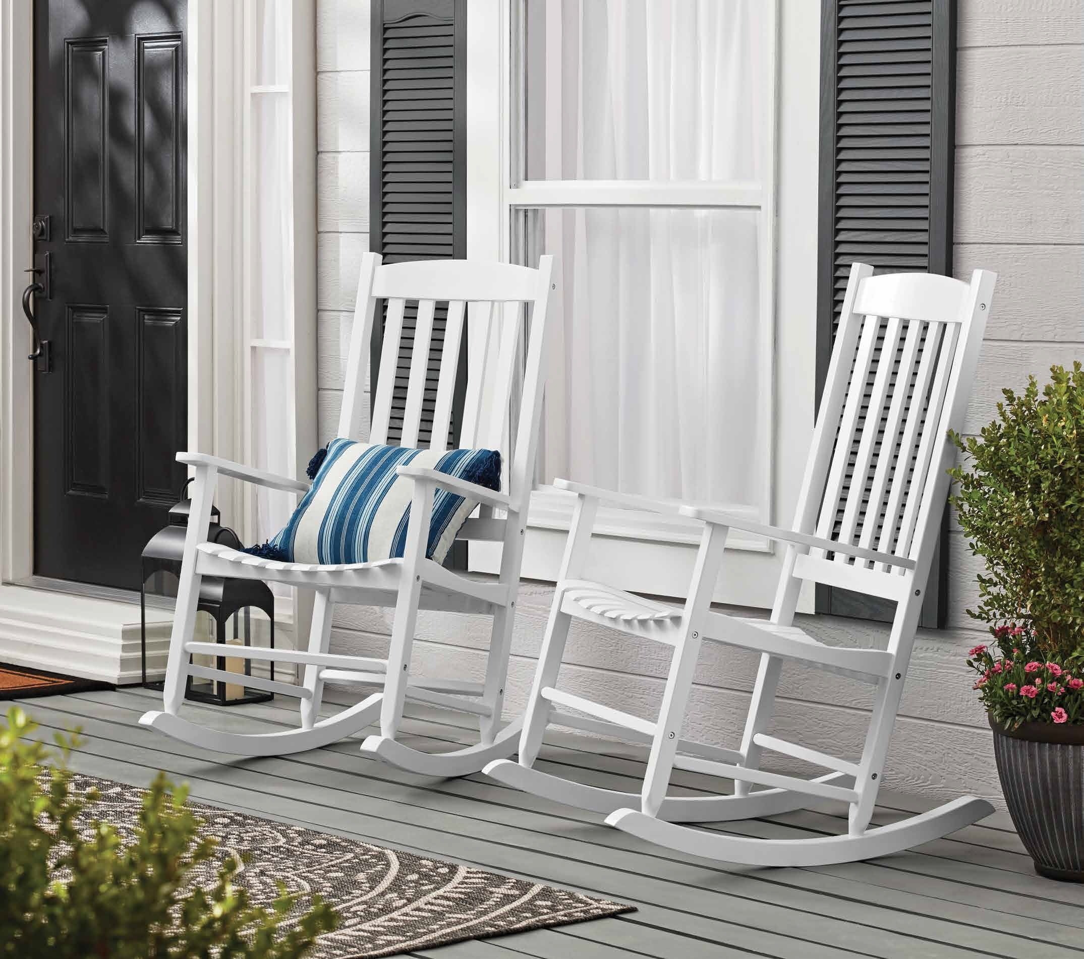 Two white rocking chairs on porch