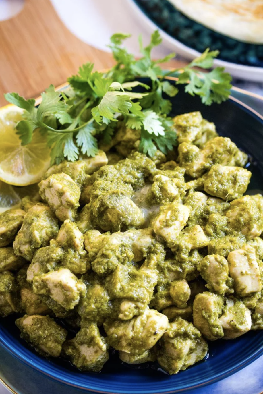 plate of green curry chicken garnished with cilantro