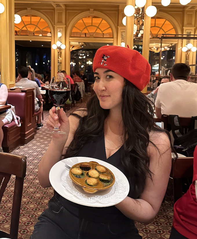 The writer posing with French food at a French restaurant.