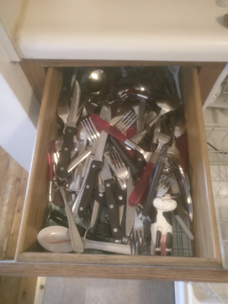 Utensils in complete disarray in a drawer