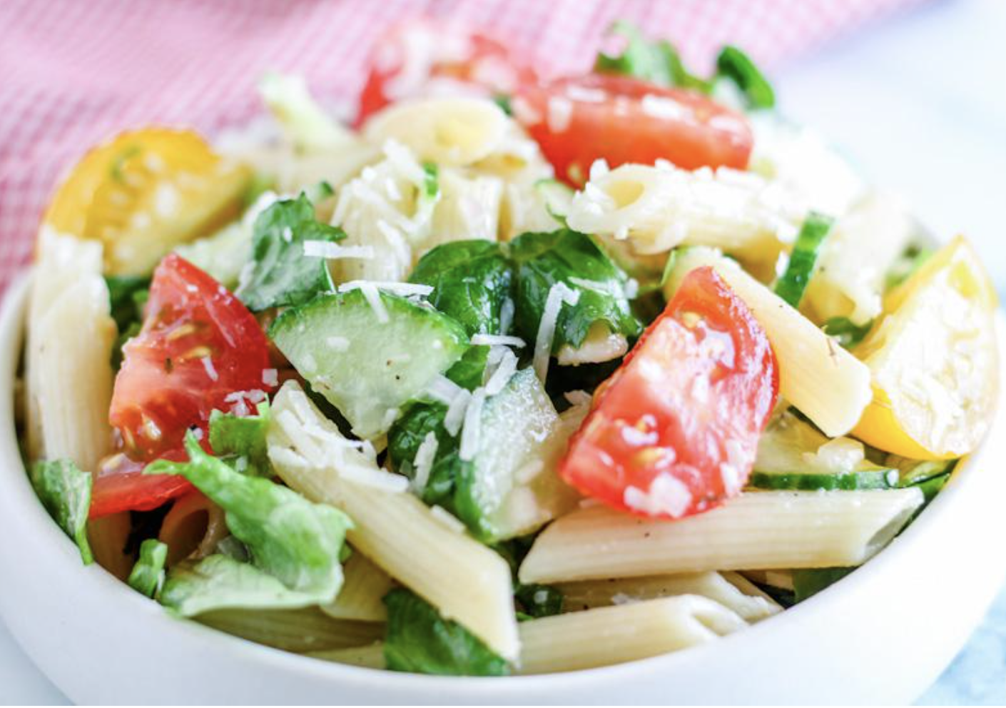 bowl of pasta salad with shredded parmesan