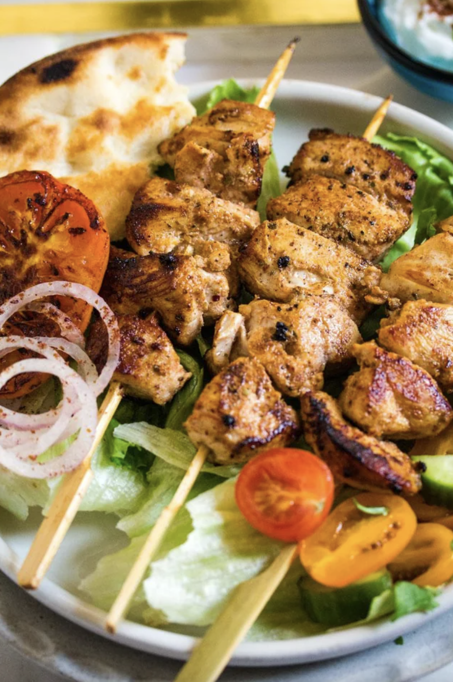 chicken skewers on a bed of lettuce
