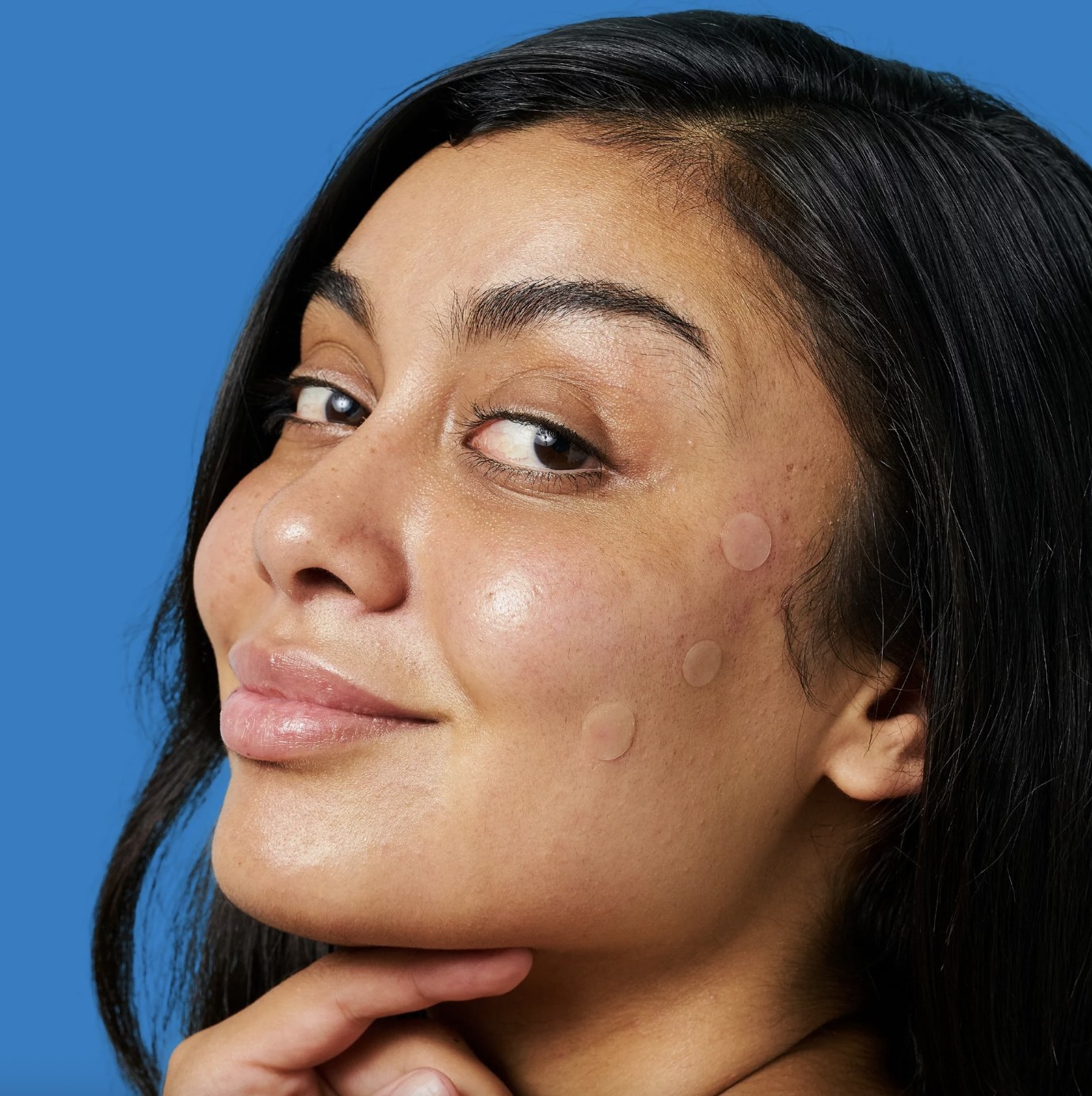 A person using acne patches