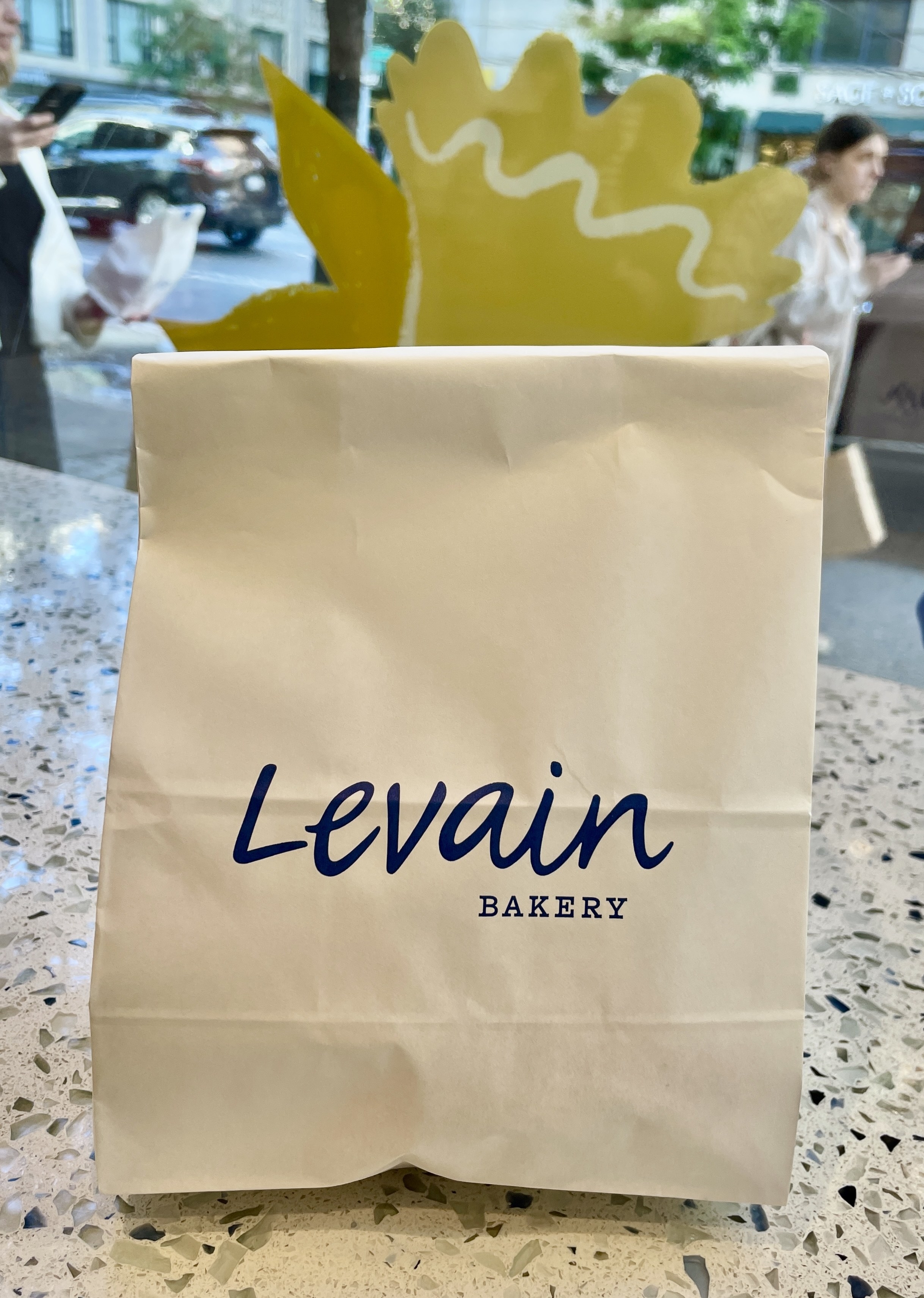 A white bakery bag with dark navy writing that says &quot;Levain Bakery&quot;