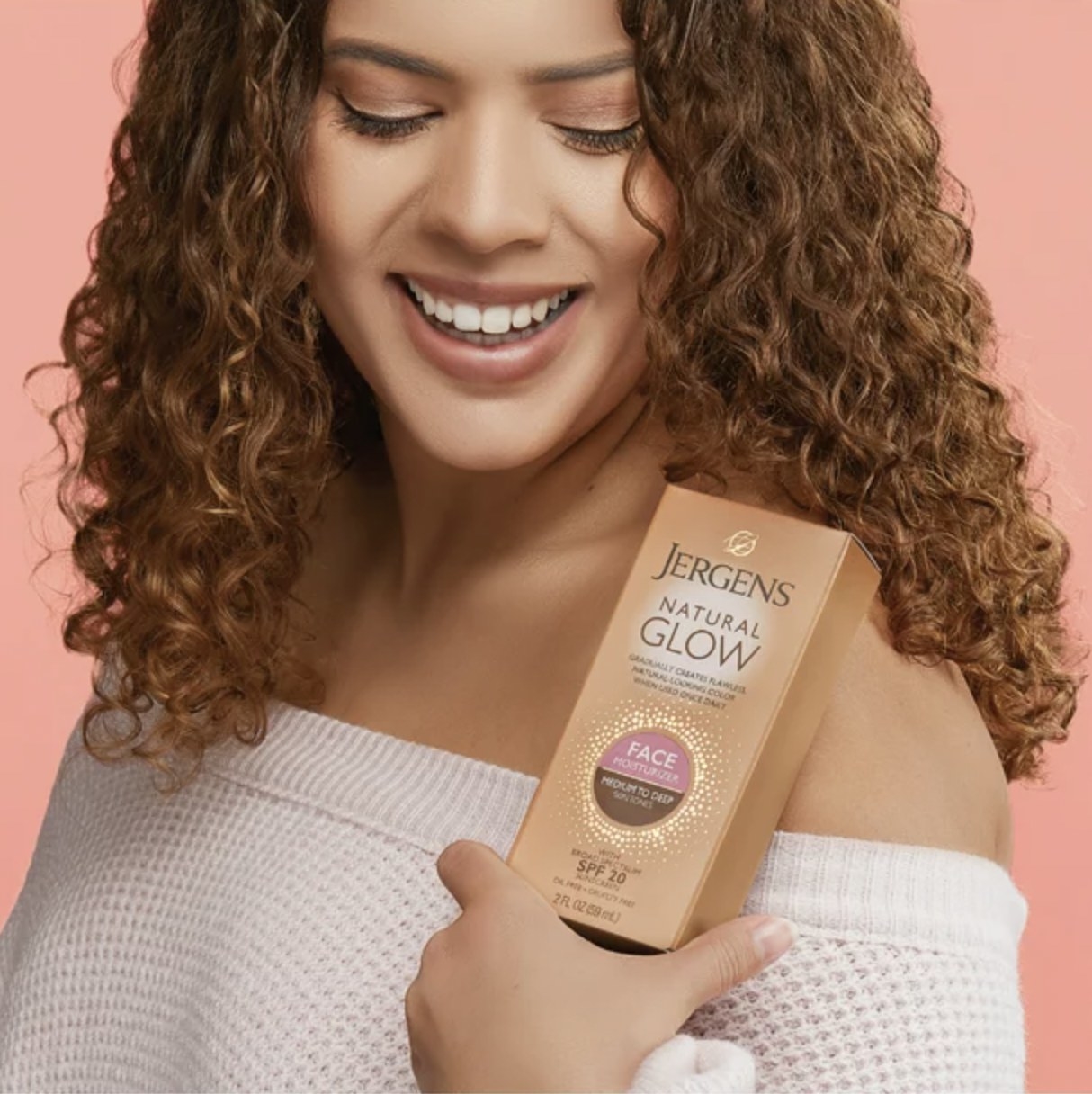 A person holding a package of self-tanner