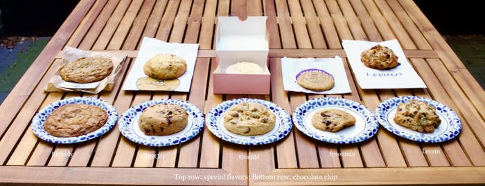 Ten cookies on a table; most are large and have visible chocolate