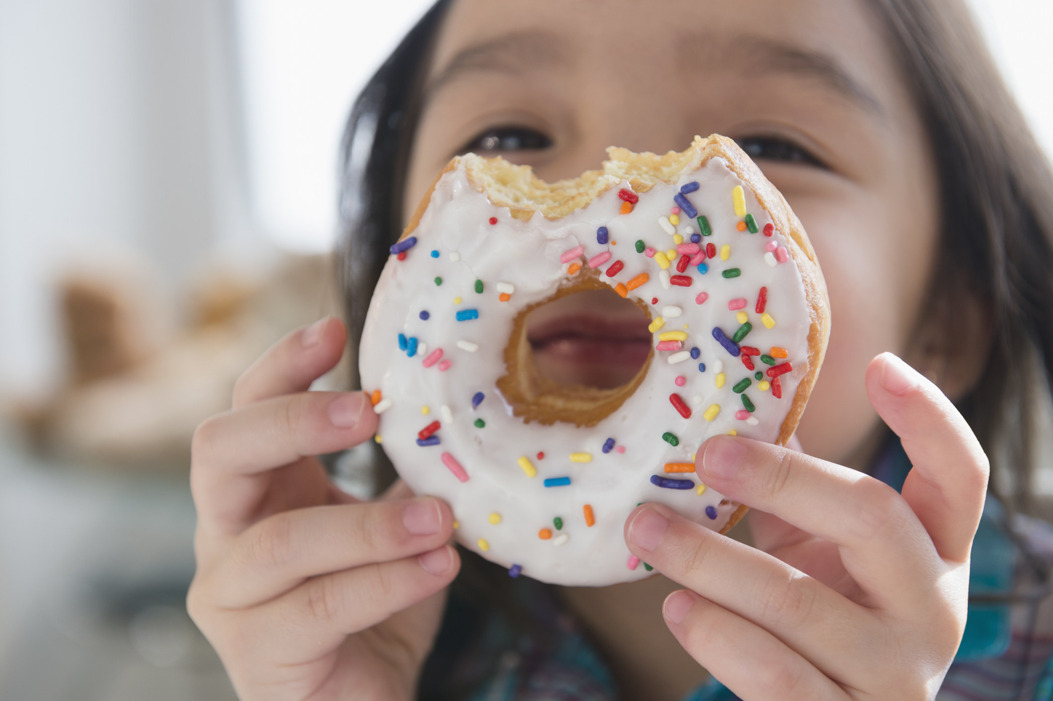 A little girl eating a donut and smiling