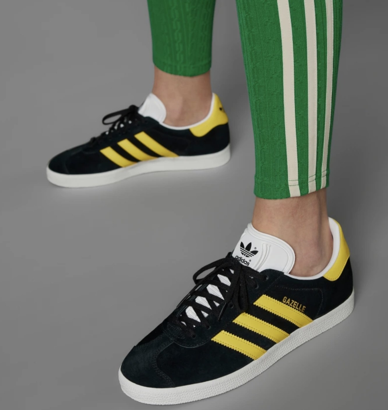 A pair of black sneakers with yellow stripes