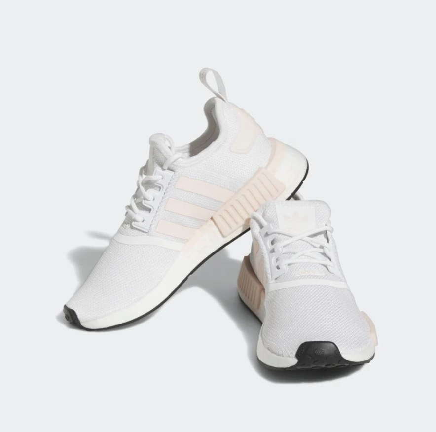 A pair of light pink and white Adidas sneakers