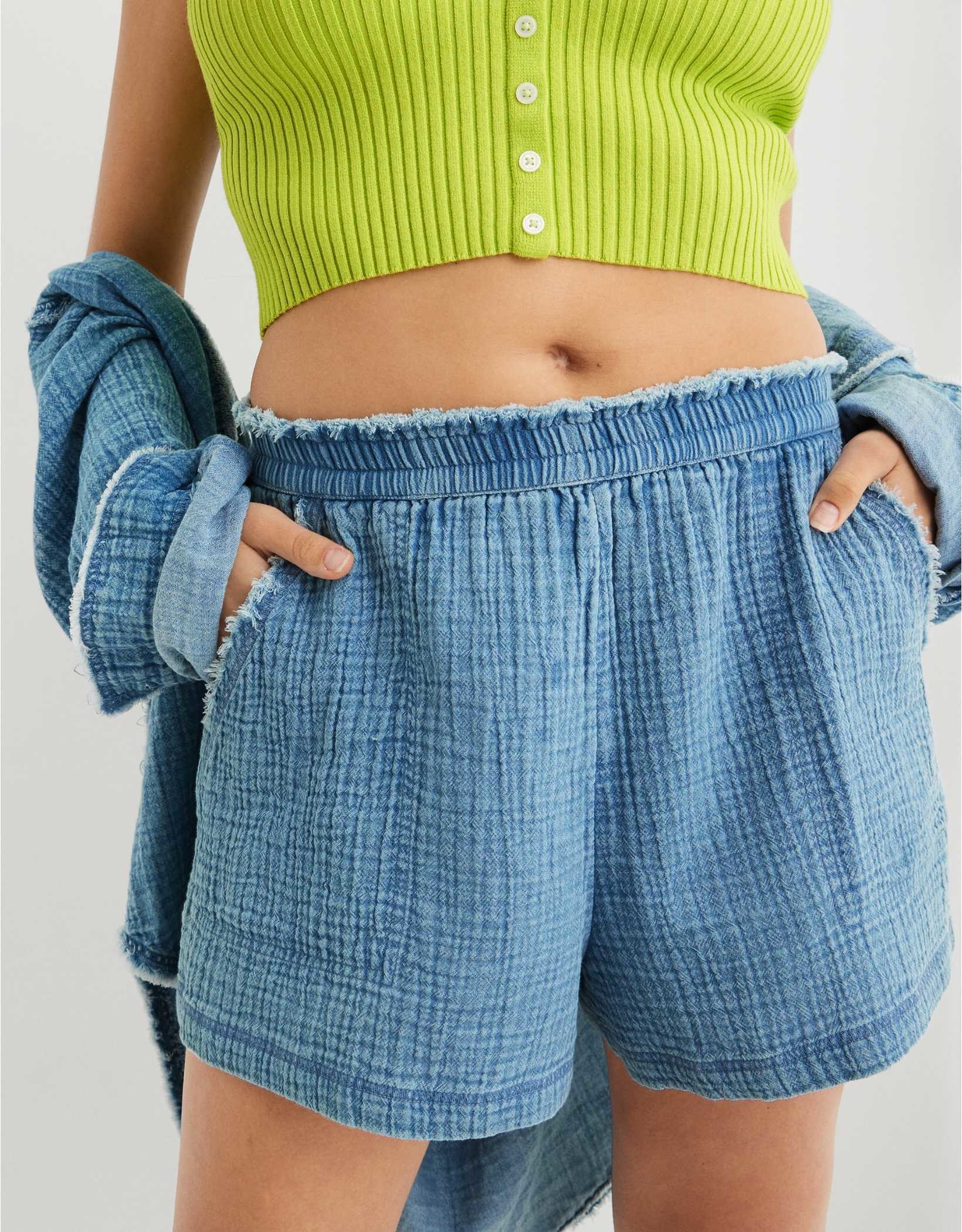 blue gauze shorts with pockets and an elastic waist with a raw hem
