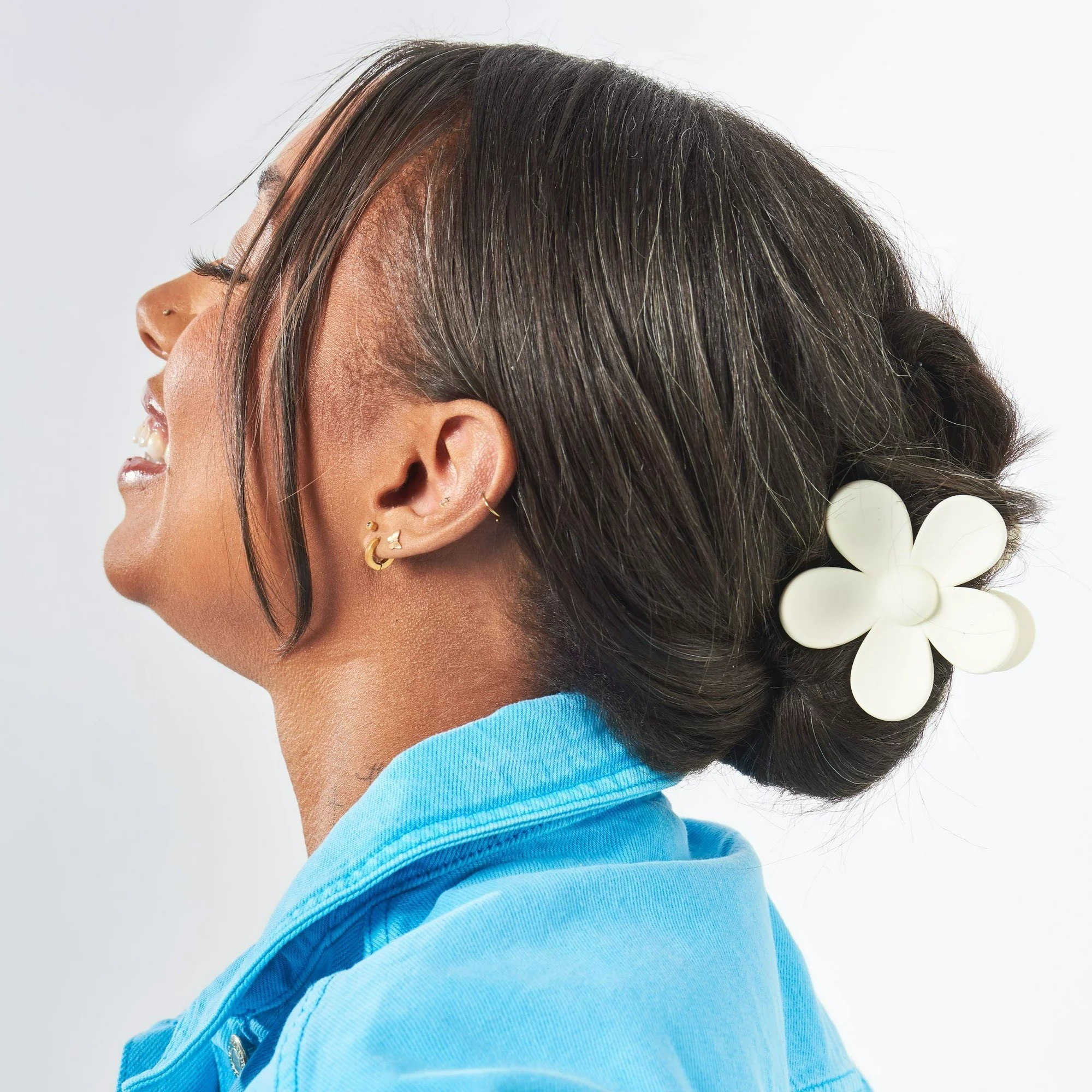 Person wearing white daisy clip in hair
