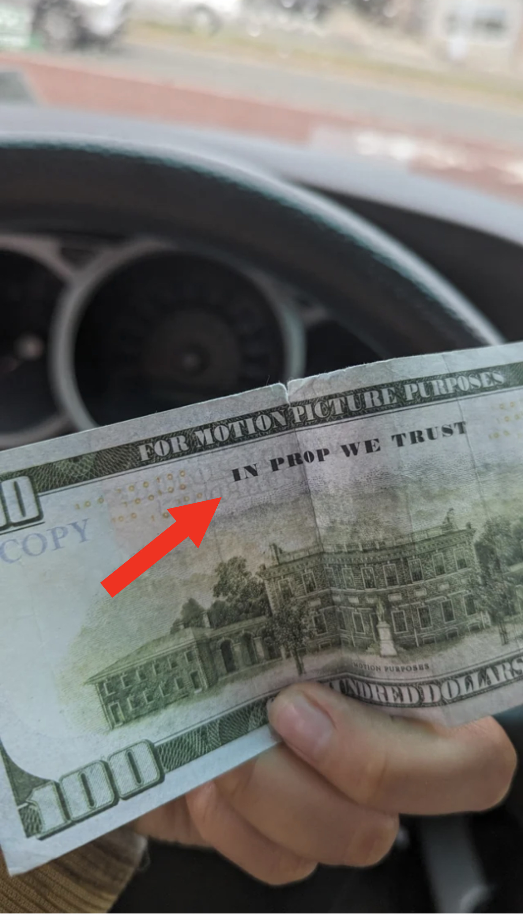 closeup of the bill with an arrow pointing to the words, in prop we trust