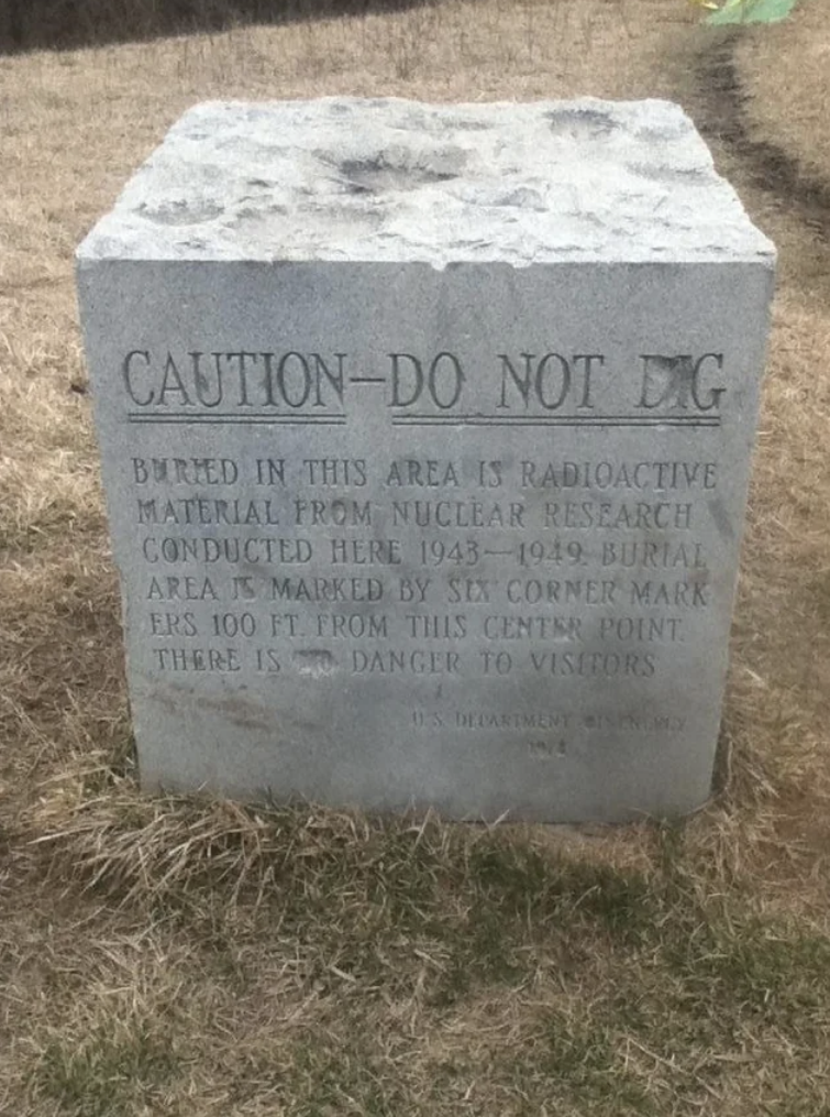 large cement block engraved with a warning not to dig