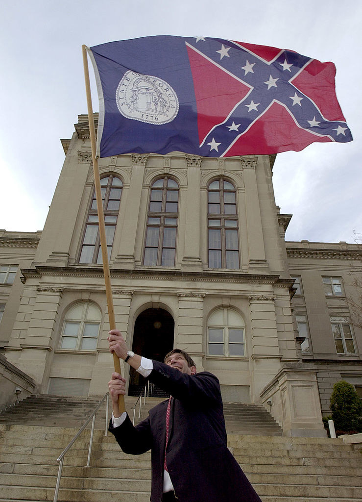 A man waving the Georgia state flag