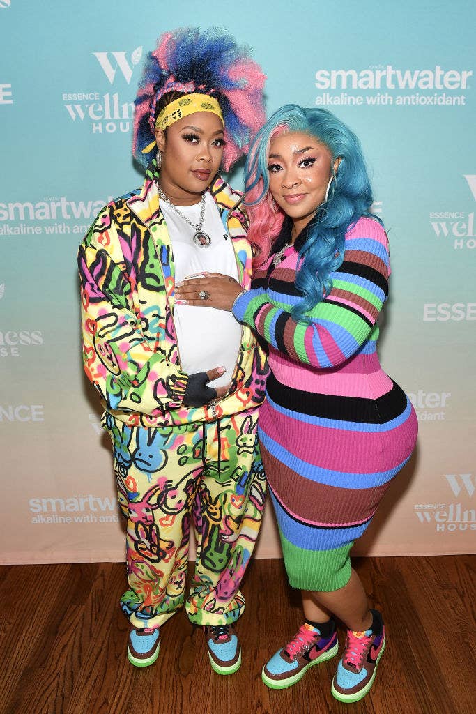 Da Brat and her wife Judy Dupart cradle Da Brat's pregnant belly as they get their photo taken