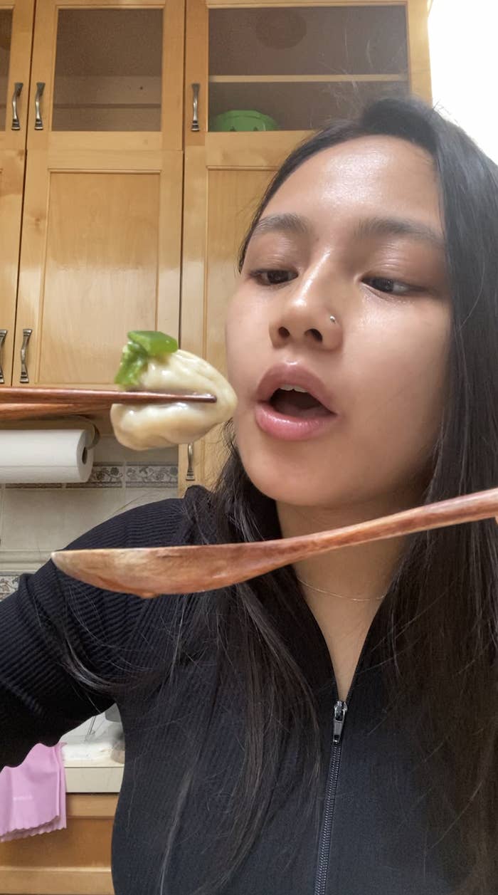 girl about to bite into a soup dumpling