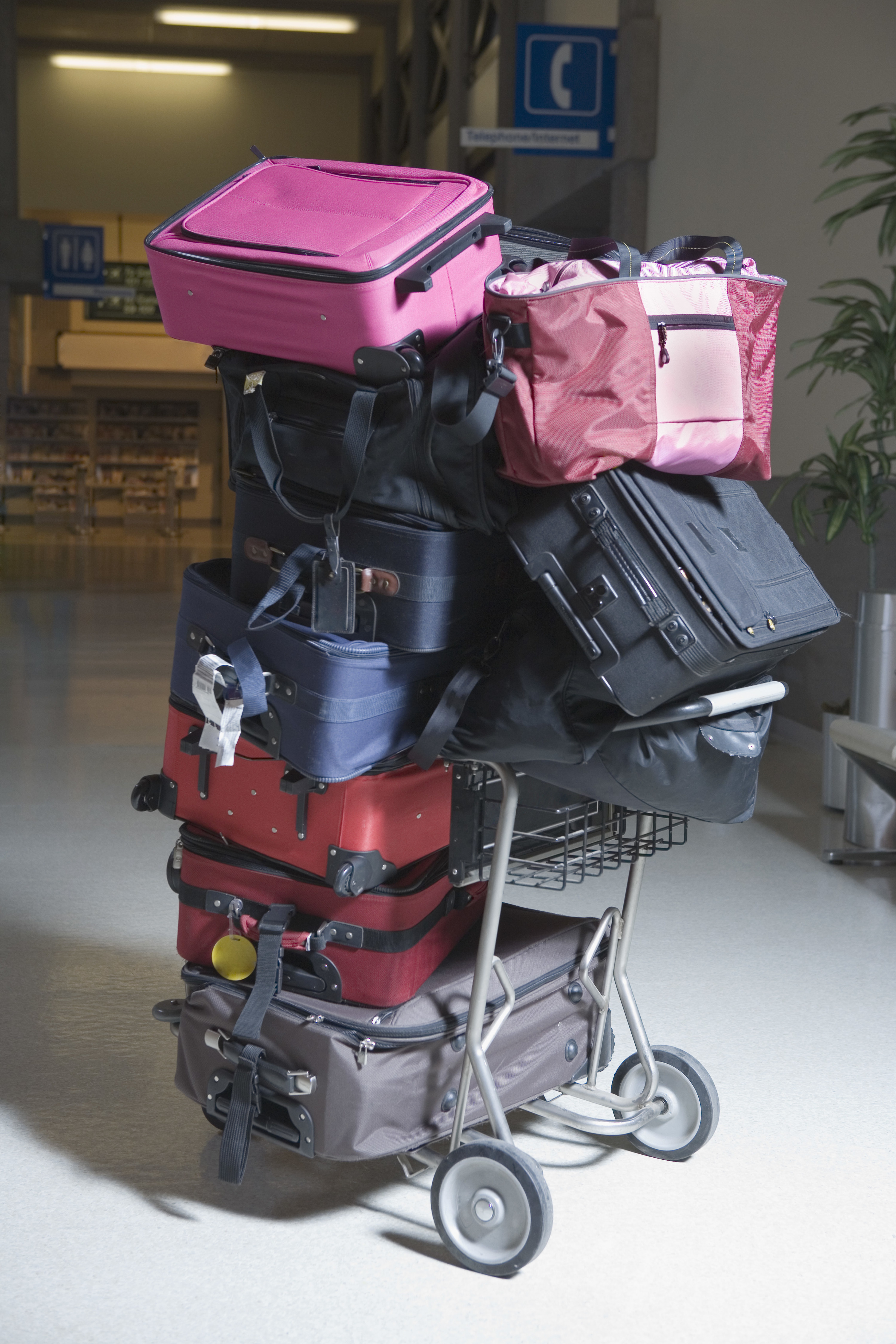 big pile of suitcases on an airport cart