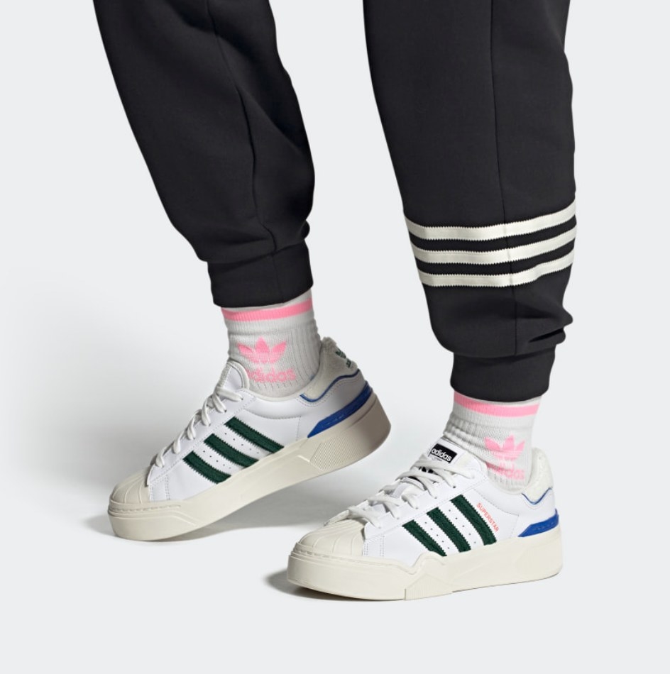 a pair of white sneakers with colored stripes
