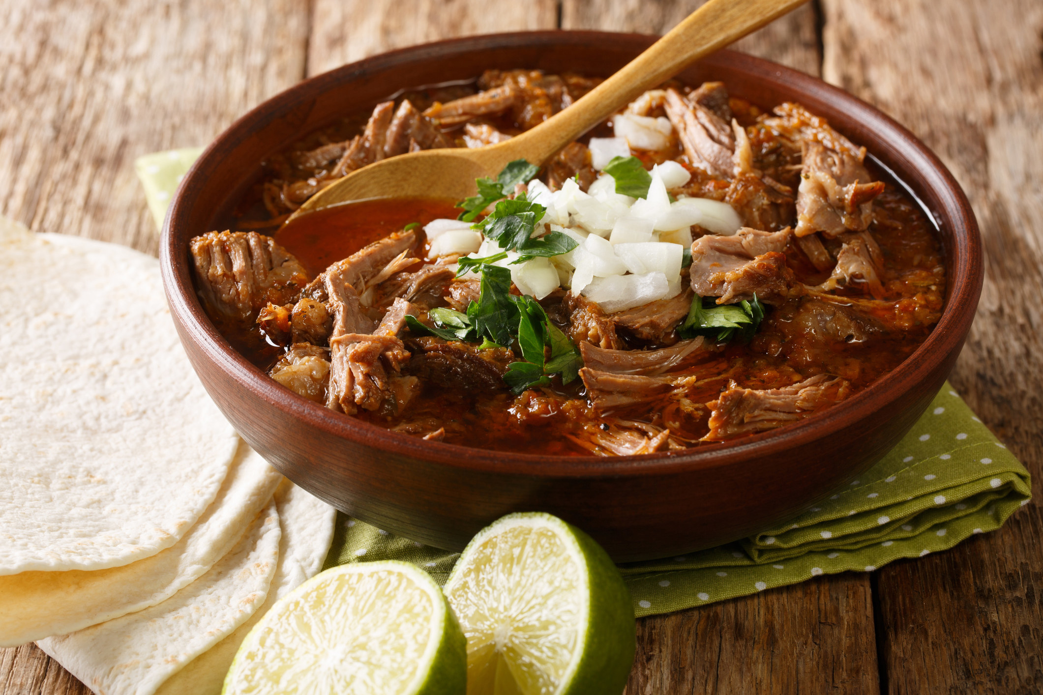 bowl of birria meat with tortillas on the side