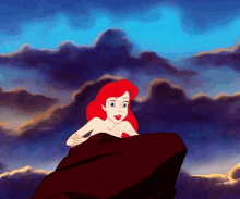 A woman poses on a rock while singing