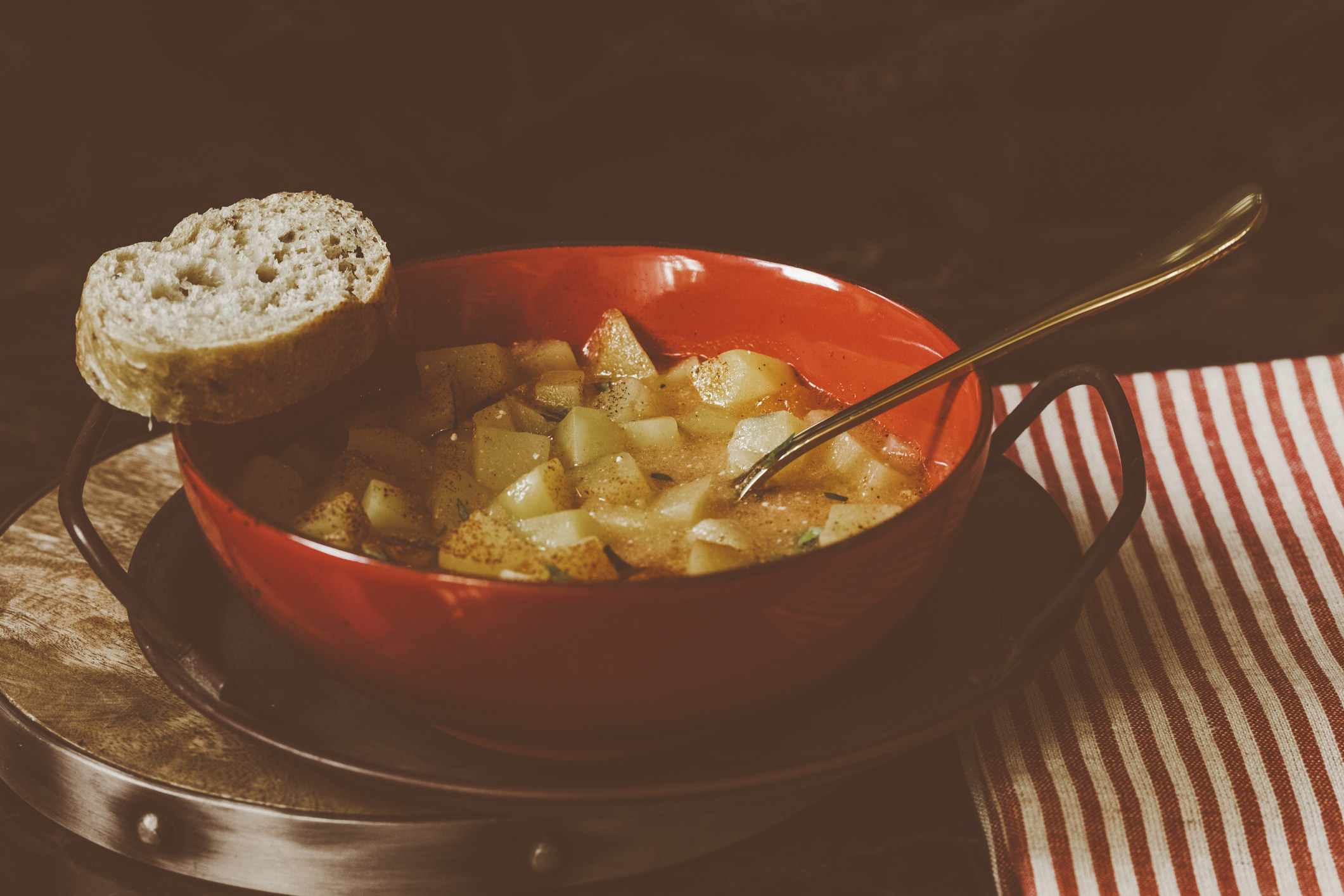 A bowl of potato soup with bread.