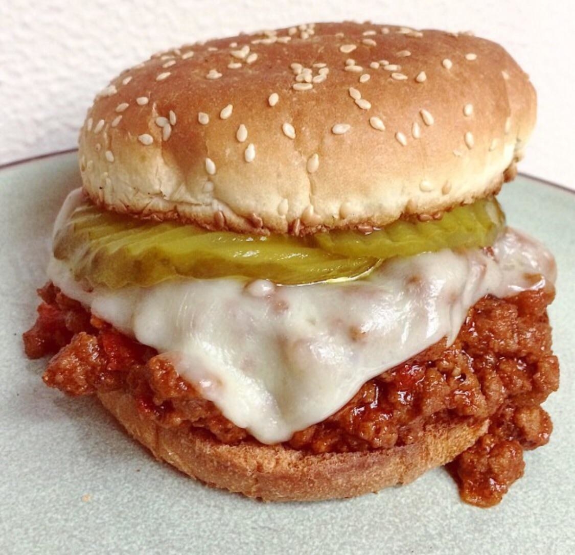 A sloppy Joe with pickles and cheese.