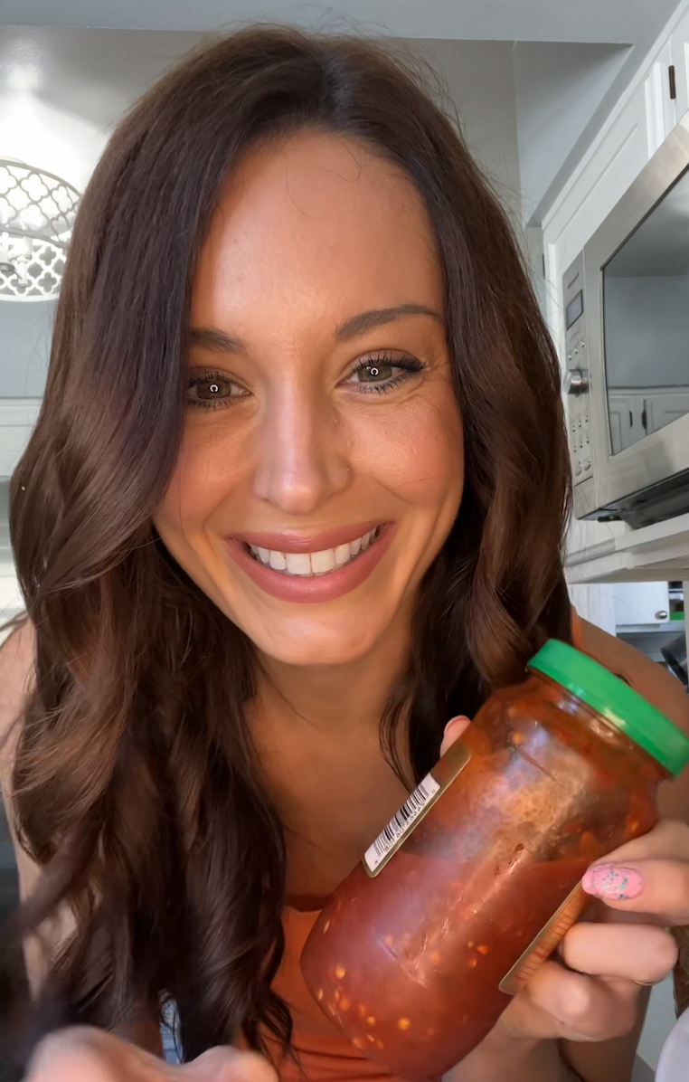 author smiling with a jar of chili sauce