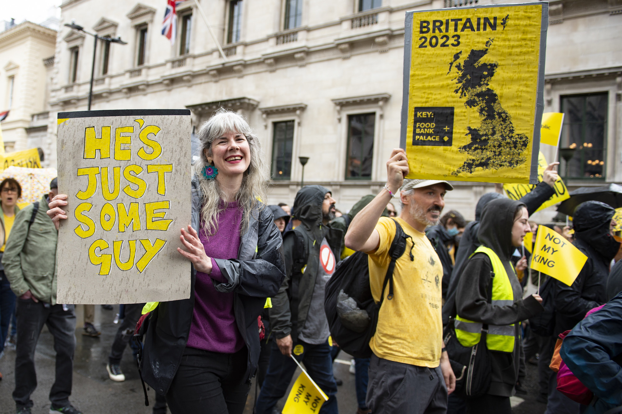 woman smiling holding a sign, he's just some guy