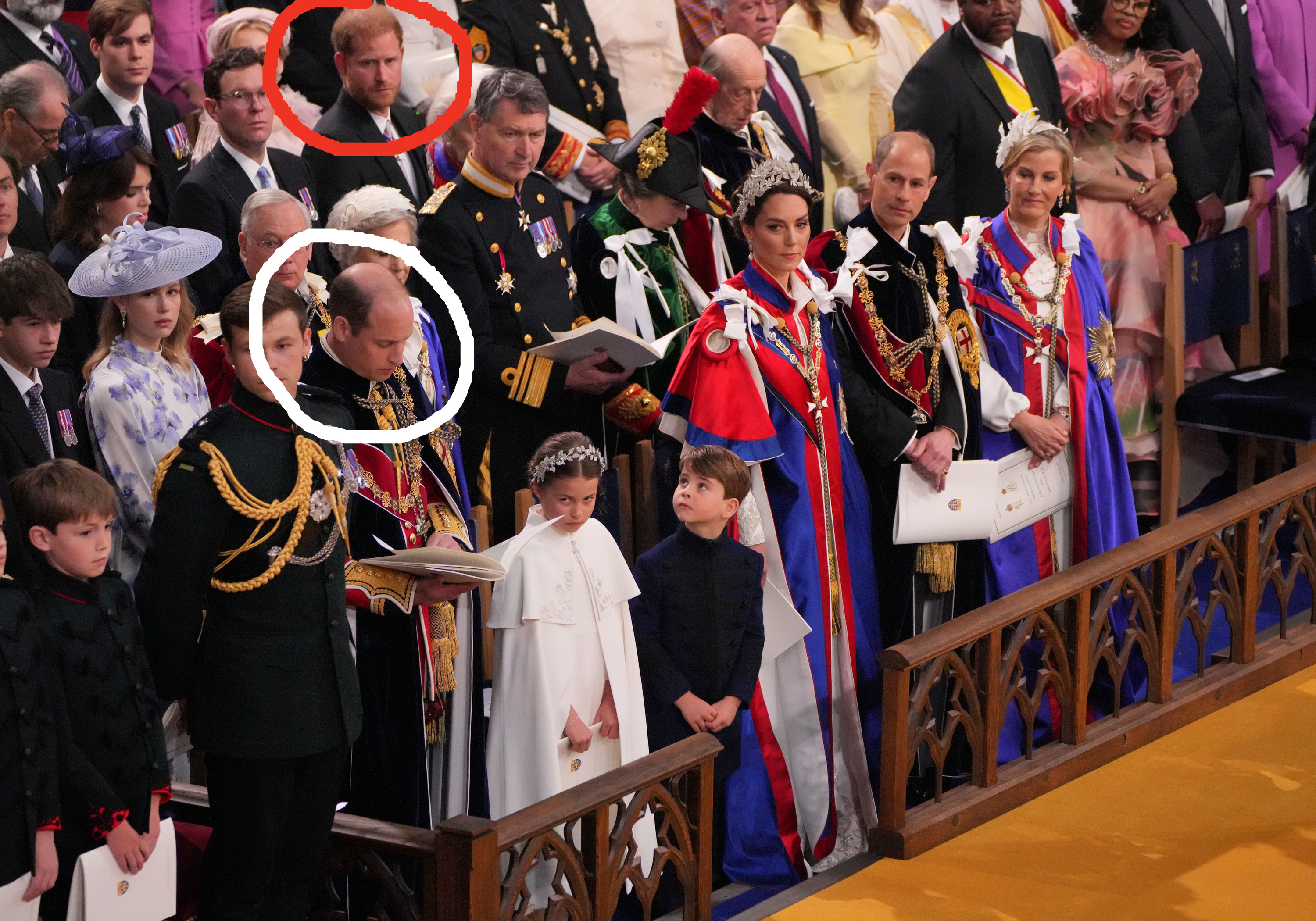 harry looking up toward william as william looks down at a booklet